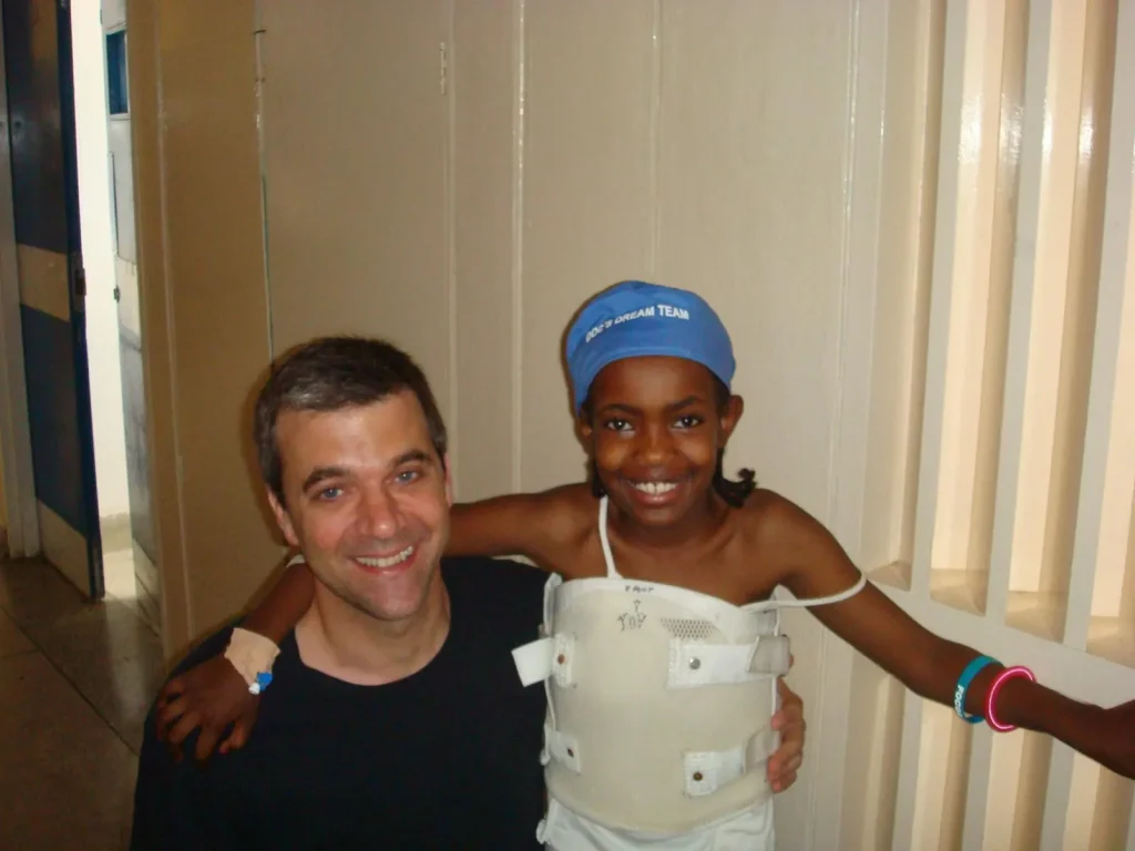 Dr. Papadopoulos with a young patient during a volunteer medical mission